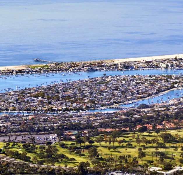 Balboa Peninsula homes near the waterfront with boats moored nearby